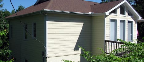 Une maison à deux étages, dotée d’un toit à pignon et d’un porche à l’avant.