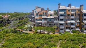 A multi-story building with a modern architectural style, featuring balconies and large windows. - IDEAL Location at Windswept, 3BD Villa, Walk-Out to Beach! (Kiawah Island)