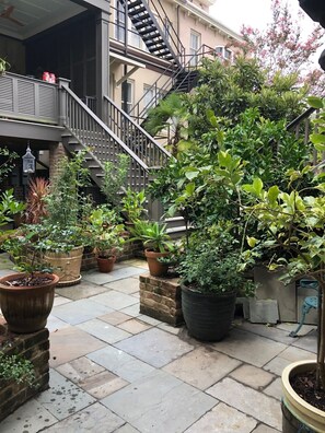 A courtyard with potted plants, a staircase, and a brick wall. - Welcome to the Nest, a unique private carriage house--Great Value! (Savannah)