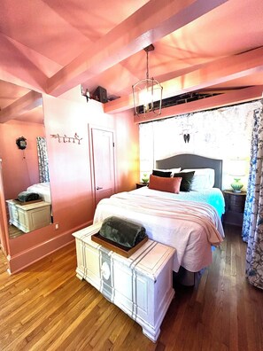 A bedroom with a bed, bedside tables, a dresser, a mirror, and a hanging light fixture. - Welcome to the Nest, a unique private carriage house--Great Value! (Savannah)