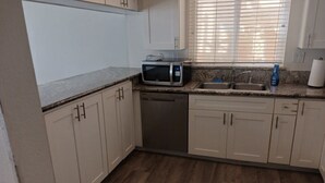 A kitchen with a microwave, dishwasher, sink, and cabinets. - Seashore Dr - 12 Bikes, 10 Boards, 8 Wetsuits, 11 Beach Chairs & Beach Toys - (Newport Beach)