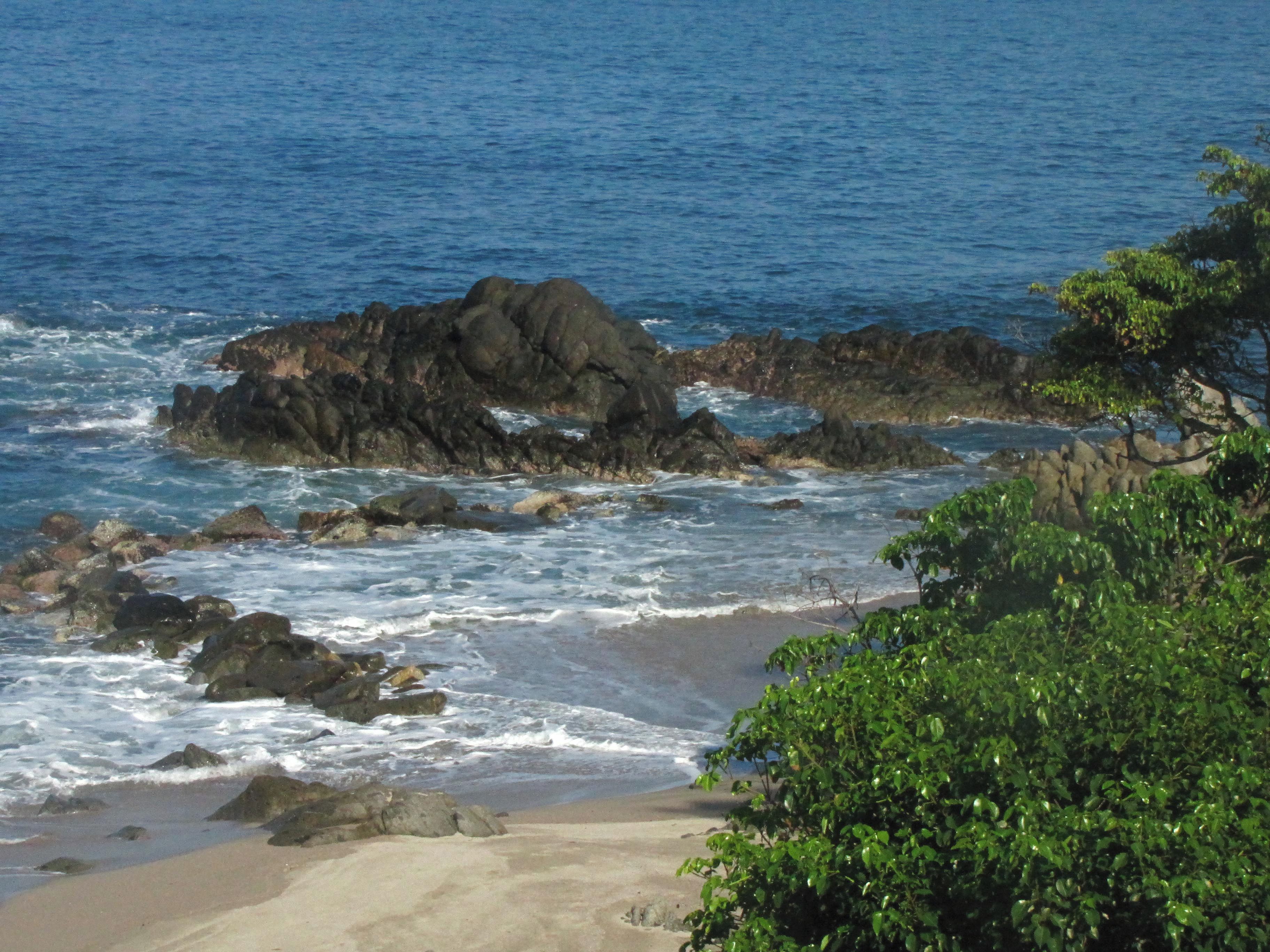 Paisaje costero con afloramientos rocosos y olas.