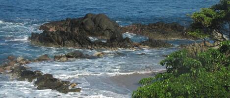 Paisaje costero con afloramientos rocosos y olas.