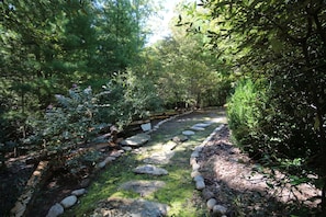 Wander along the serene garden pathway, lined with stepping stones and lush greenery.
