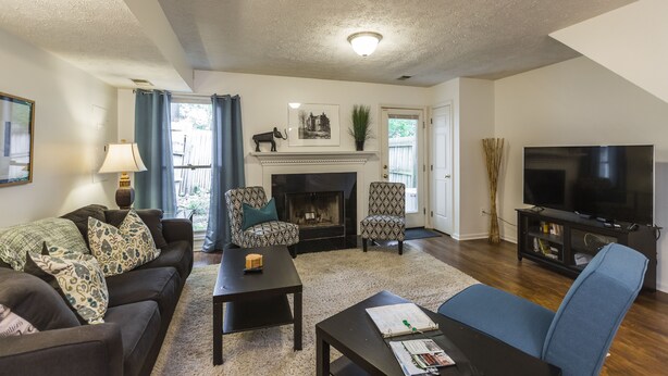 A living room with a fireplace, a television, and a sofa. - A Renovated 3 Bedroom, 2.5 Bath Townhouse In Downtown Lexington. (Lexington)