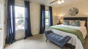 A bedroom with a bed, a bench, a ceiling fan, and a window with curtains. - A Renovated 3 Bedroom, 2.5 Bath Townhouse In Downtown Lexington. (Lexington)