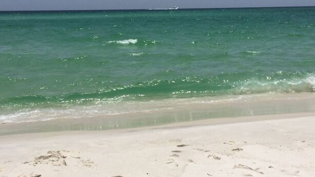 Una playa con agua turquesa cristalina y arena blanca.