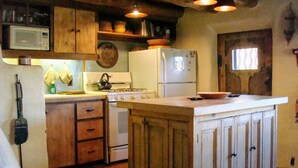 Una cocina con armarios de madera, estufa, microondas y refrigerador.