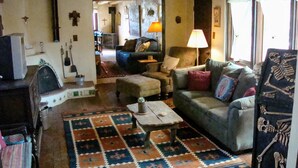 Una sala de estar acogedora con un tapete estampado, un sofá, una mesa de centro y una chimenea.