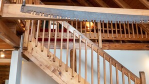 Un escalier en bois, doté d’une rampe, qui mène à un niveau supérieur.