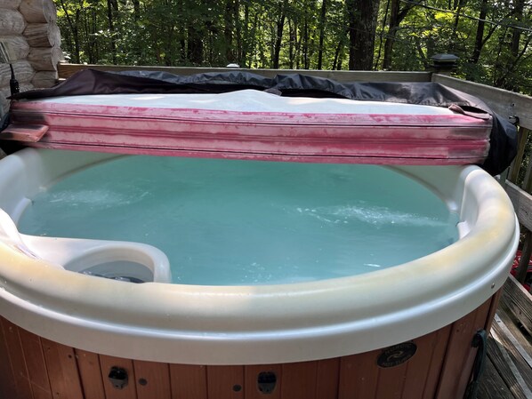 A hot tub with a wooden exterior, surrounded by a wooden deck and trees. - Beautiful Log Chalet, Hot Tub, Gas Grill, Secluded 6 wooded acres. Best privacy (Stanley)