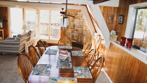 A dining area with a wooden table, chairs, and a stone fireplace. - Free Arcade Room- Great views-1/2 Mi Ski Slopes, 3 Mi. Dwntwn (Gatlinburg)