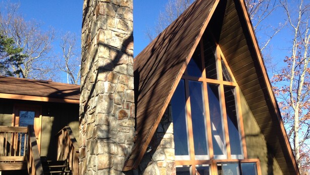 A cabin with a stone chimney, wooden exterior, and a staircase leading to the entrance. - Free Arcade Room- Great views-1/2 Mi Ski Slopes, 3 Mi. Dwntwn (Gatlinburg)