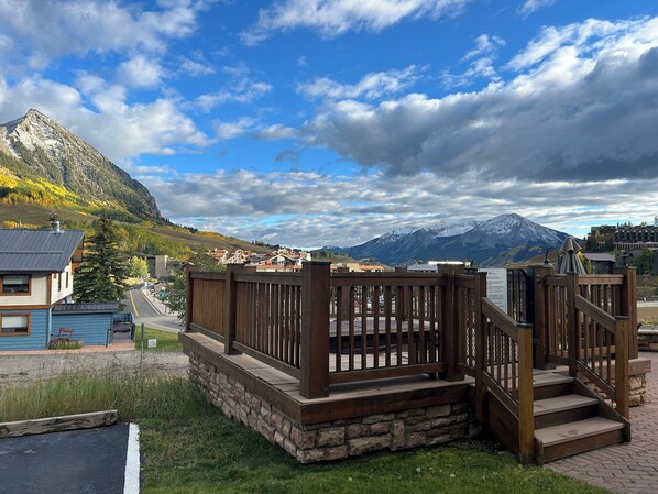 A wooden staircase leading to a deck with a mountain view.