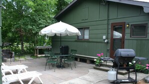 En terrasse med udendørs møbler, grill og gasbeholder.