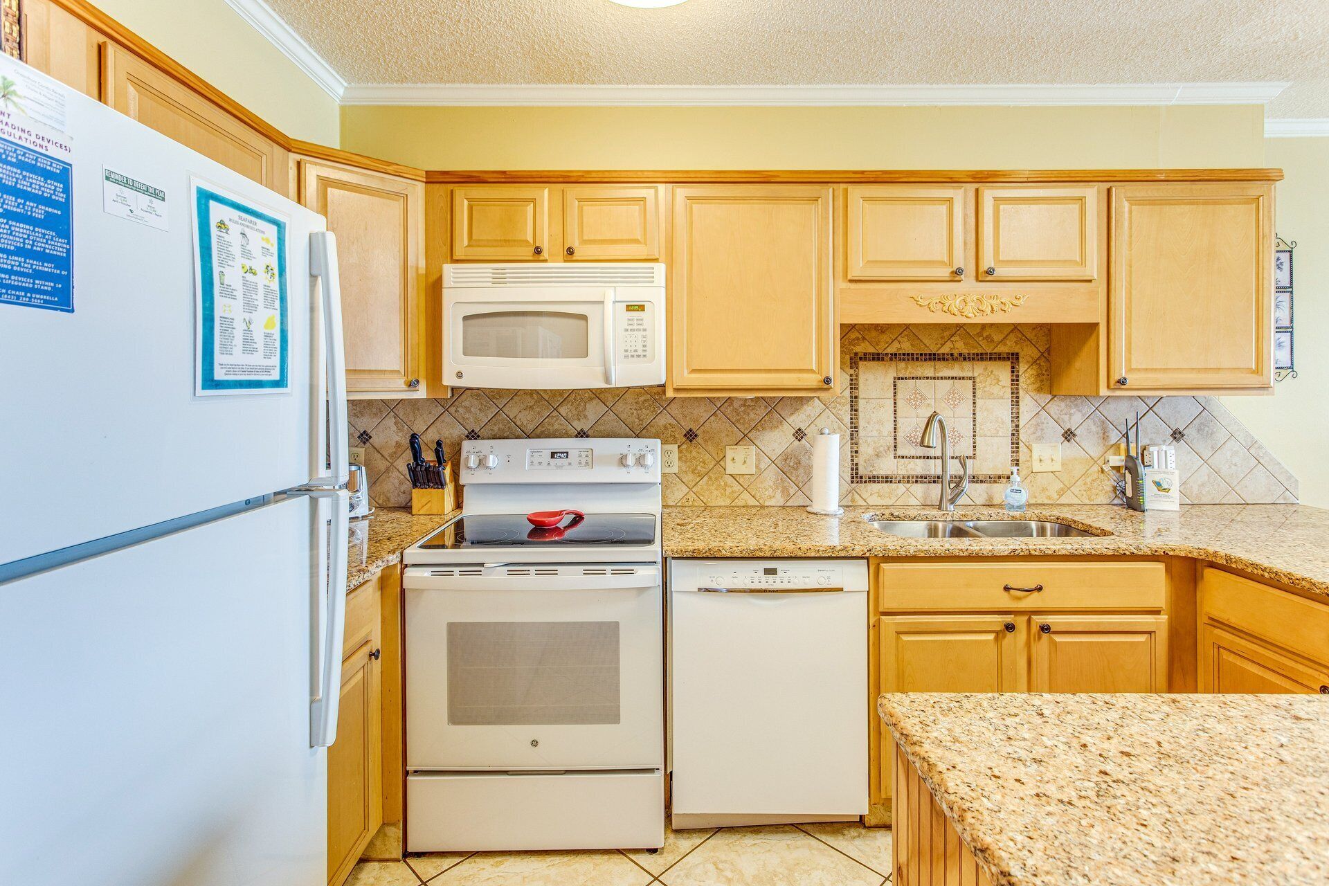 A kitchen with wooden cabinets, a microwave, stove, oven, and dishwasher.