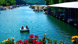 A calm lake with boats and a docked boat on the right.