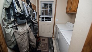 A laundry room with a washing machine, a drying rack, and a door with a window.