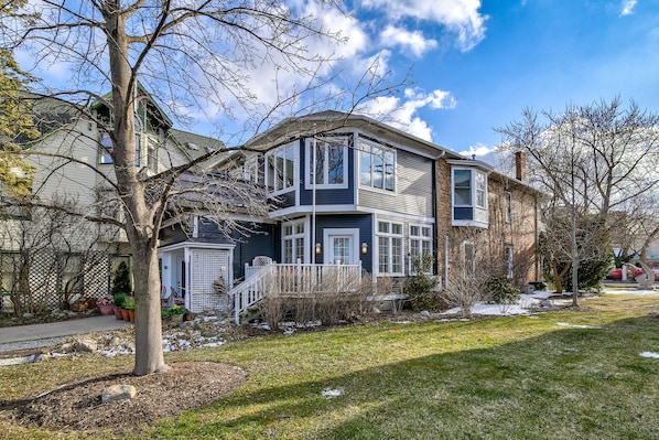 A two-story house with a front porch, a covered entryway, and a visible staircase leading to the upper floor. - Bayfront King, Harbor View & Porch,Parking, Location! (Saugatuck)