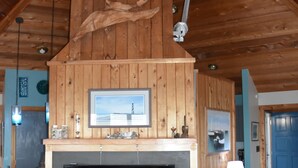 A wooden interior with a fireplace, television, and ceiling fan. - OCEANFRONT☆One level living w/ramp access to house & dune deck. Walk to dining!  (Kitty Hawk)