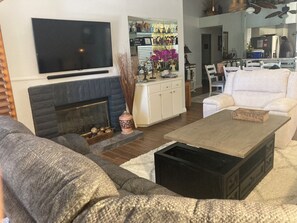 Uma sala de estar com lareira, televisão e mesa de centro.