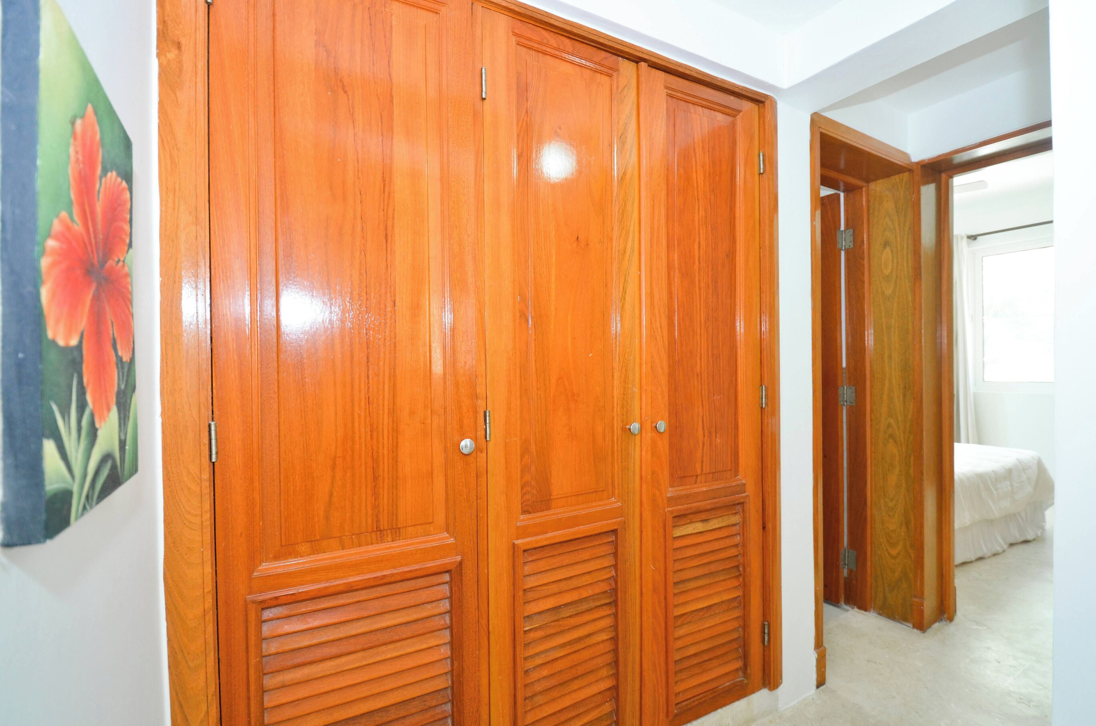 Un armario de madera con dos puertas y una ventana pequeña.