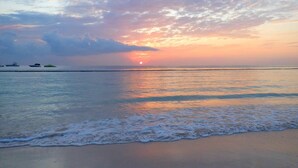 A beach with calm waters and a sunset. - Playa Turquesa, Beachfront, Ocean view, pool, 2 Bd. Luxury Condo, Wifi, Smart TV (Bavaro)