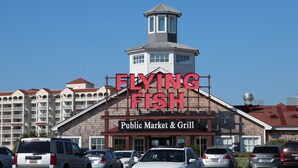 A building with a sign reading "FLYING FISH Public Market & Grill" and a tower structure.