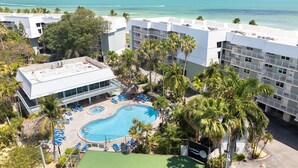 Un resort con piscina, palmeras y vista al océano.