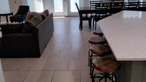 Eine geräumige Küche mit Essbereich, einer Bar und einer Sitzecke mit Sofa und Sesseln.