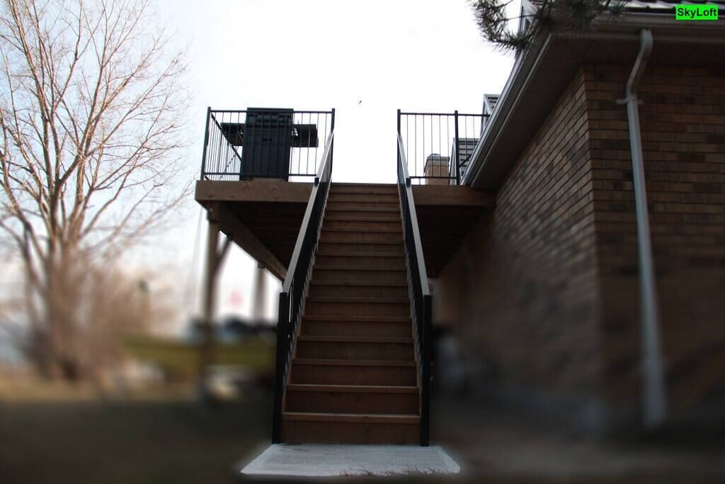 Eine Treppe führt zu einem Balkon mit einem Mülleimer und einem Schild, auf dem 'Sky Loft' steht.
