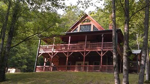 A two-story log cabin with a balcony, surrounded by trees. - Private Mountain Hideaway (Andrews)