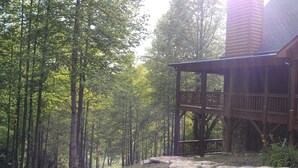A wooden cabin with a stone foundation, surrounded by a forest. - Private Mountain Hideaway (Andrews)