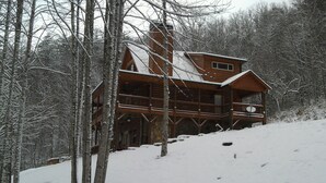 A log cabin with a balcony, surrounded by snow-covered trees. - Private Mountain Hideaway (Andrews)