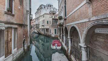 Un canal étroit, bordé de bateaux, de bâtiments historiques et d’un pont.