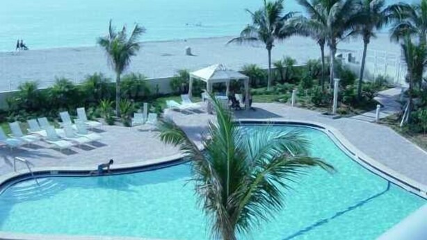 Zona de piscina con vista a la playa y al océano.