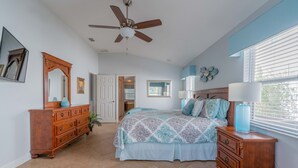 A bedroom with a bed, dresser, and ceiling fan. - Near Disney and USTA tennis campus - Pool Villa on the Lake - Stunning Views! (Kissimmee)