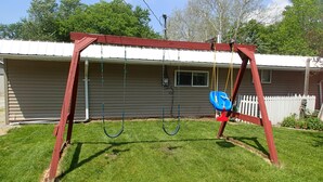 A swing set in a backyard with a house in the background. - 3 bedrooms sleeps up to 10 people (Warsaw)