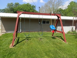 A swing set in a backyard with a house in the background. - 3 bedrooms sleeps up to 10 people (Warsaw)