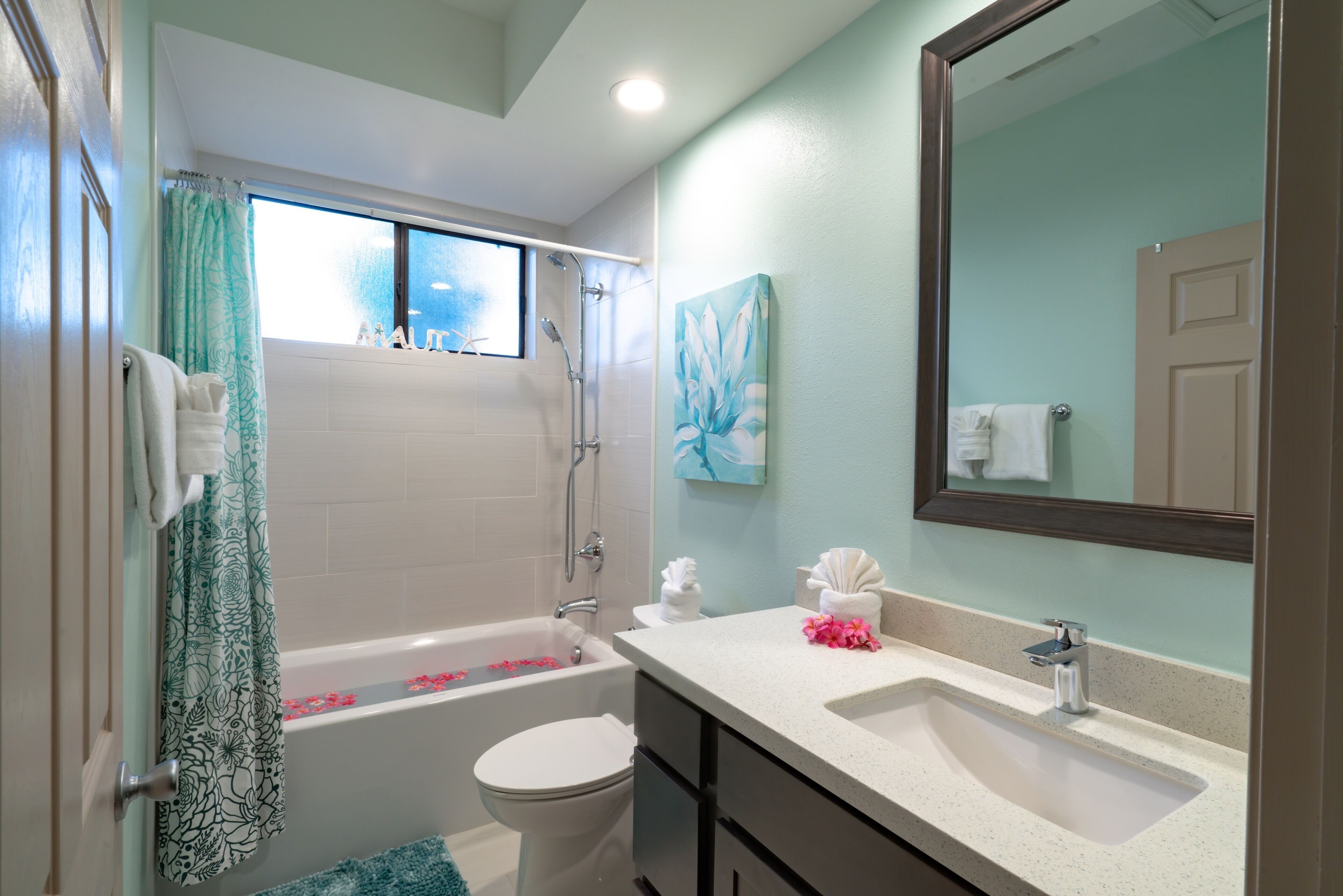 Une salle de bain avec une baignoire, des toilettes, un lavabo et un grand miroir.