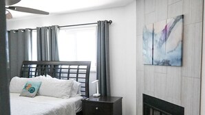 A bedroom with a bed, bedside table, and a fireplace. - Amazing Proximity to the Beach and Bay with Direct Ocean Views! (San Diego)