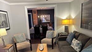A living room with a sofa, two armchairs, a coffee table, and a dining area in the background. - Entire house 10 minute walk to The Falls and all Attractions! No Car Needed (Niagara Falls)
