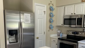 A kitchen with stainless steel appliances, a white countertop, and a door with a note. - Family & Pet-Friendly,  Near Beaches + Restaurants,  2BR, 2BA (Wilmington)