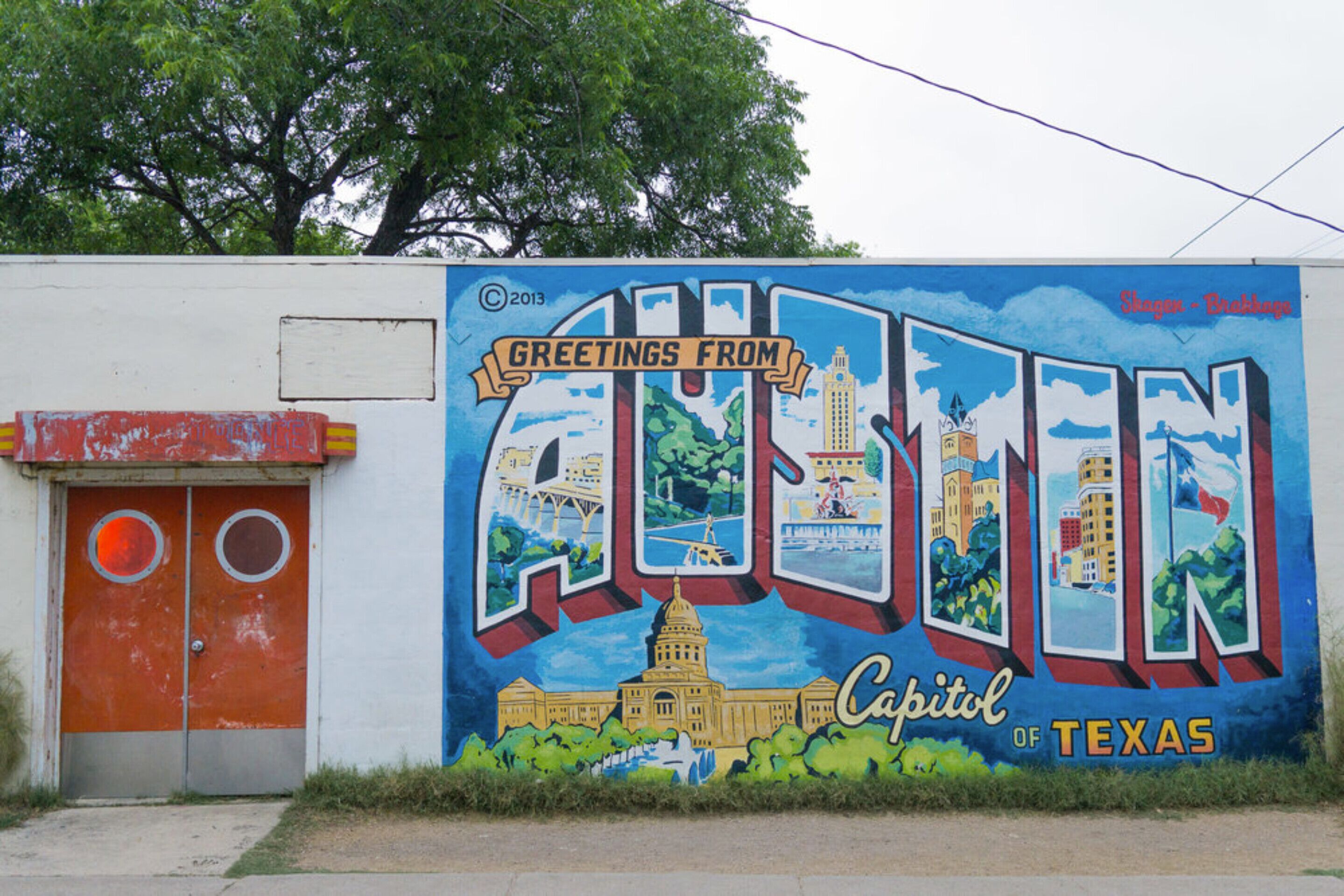 A mural with 'Greetings from Austin, Capital of Texas' and a depiction of the Texas State Capitol.