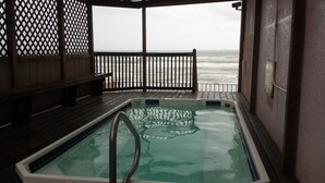 A hot tub with a wooden deck and a view of the ocean. - Beachfront View from 9th Floor (South Padre Island)