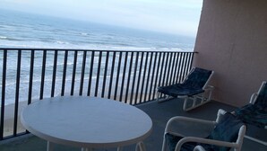 A balcony with a white table and two chairs, overlooking the ocean. - Beachfront View from 9th Floor (South Padre Island)