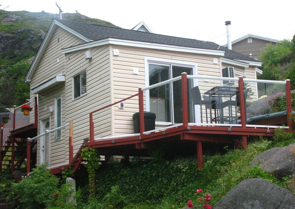 Ein Haus mit Terrasse, Treppe und Fenster.
