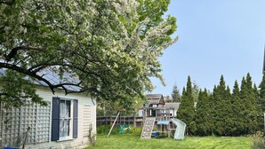 A backyard with a hammock, a swing set, and a playhouse. - Trackside Home- Walk to Everything (Track, Town, SPAC) (Saratoga Springs)
