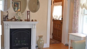 A room with a fireplace, a mirror, a door, and a chair. - Trackside Home- Walk to Everything (Track, Town, SPAC) (Saratoga Springs)
