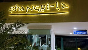 A hotel entrance with a neon sign reading "shangri-la" and a sign for "Visitantes". - Paradise at Shangrila, Beachfront (Puerto Vallarta)